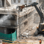 A demolition contractor applying safe building demolition practices while demolishing a building