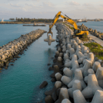 A breakwater construction in india with an excavator working at a site.